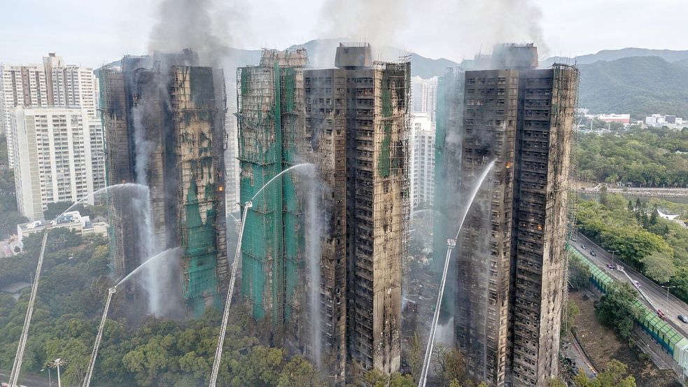Auch fast 20 Stunden nach Ausbruch des Feuers kämpften die Einsatzkräfte noch gegen Flammen. Foto: Vernon Yuen