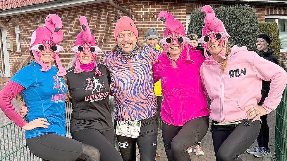Organisator Ingo Hellmers (Mitte) ist selbst gerne farbenfroh unterwegs. Am Samstag wurde er von vier Frauen seiner Gruppe „Laufhaufen Ostfriesland“ überrascht, die sich Flamingo-Kopfbedeckungen besorgt hatten. Fotos: Privat