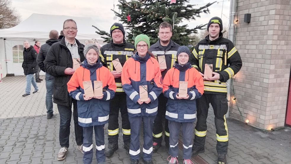 Pastor Holger Rieken (von hinten links, Kirchengemeinde Ostrhauderfehn/Holterfehn), Markus Ahrenholz, Hendrik Willms, Dennis Wachsmann, Tida Hessenius (vorne von links), Jana Schmidt und Hanna Kasperczyk freuen sich, dass der Adventsmarkt ein Erfolg war. Foto: Clarissa Scherzer