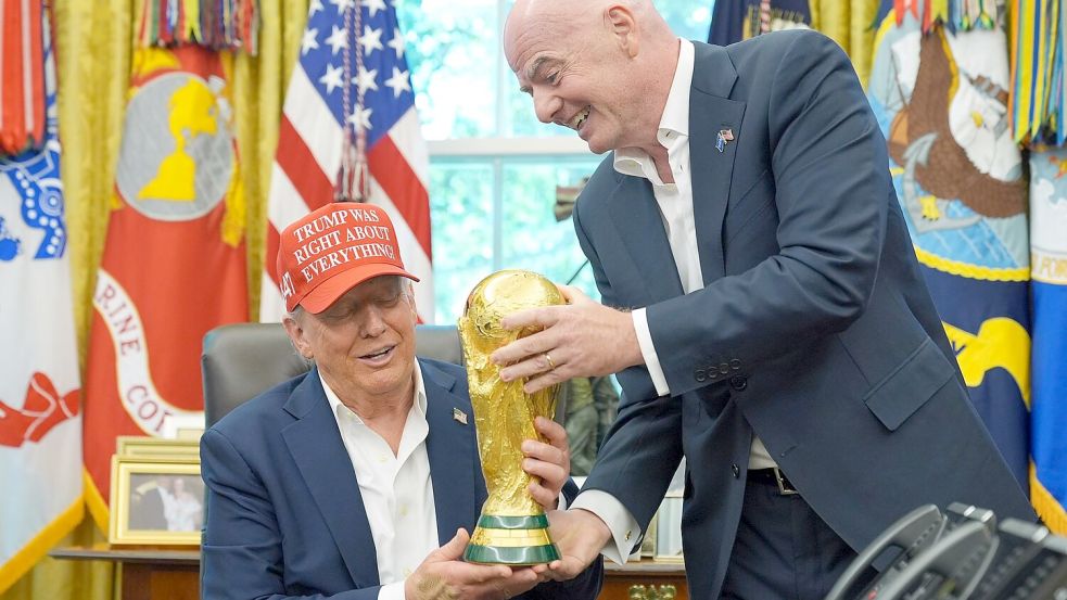 US-Präsident Trump (l.) und FIFA-Chef Infantino (r.) zeigen den WM-Pokal. (Archivbild) Foto: Jacquelyn Martin/AP/dpa