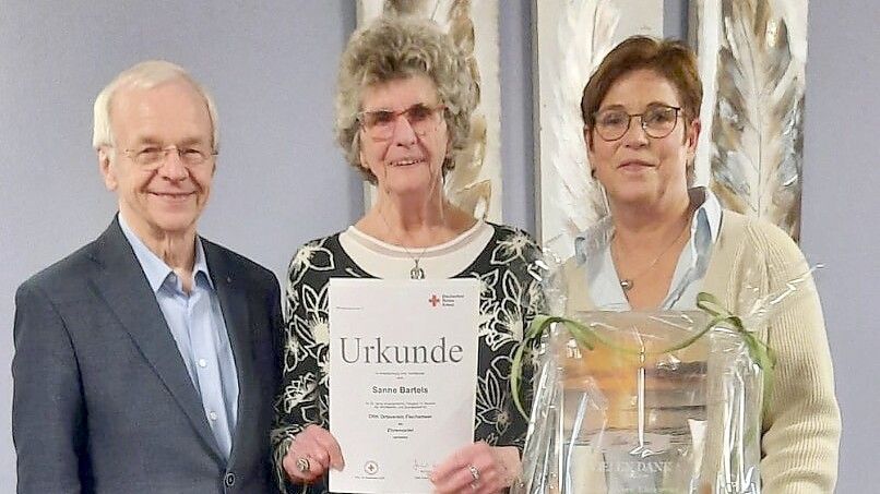 Auf dem Foto: Links Bernhard Bramlage, Präsident des DRK-Kreisverbandes Leer, in der Mitte Sanne Bartels, die für 25 Jahre DRK-Einsatz geehrt wurde, und rechts Maria Robben, 1. Vorsitzende des Ortsvereins. Foto: Maria Robben