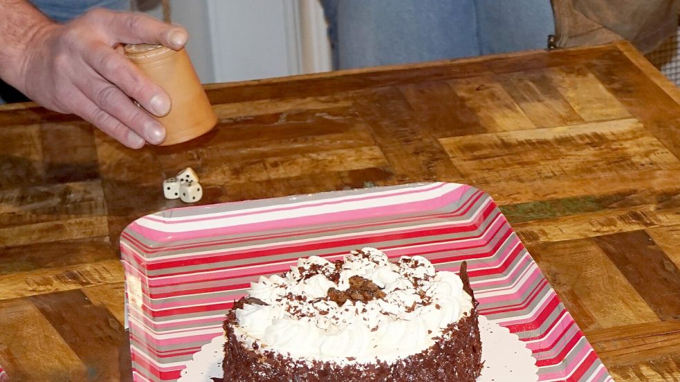 Beim traditionellen Verknobeln in Ostfriesland kommen Jung und Alt zusammen, um mit Würfeln regionale Spezialitäten wie Wurst, Schinken und Torten zu gewinnen. Die geselligen Abende sorgen jedes Jahr für viel Spaß und Gemeinschaft in den Dörfern. Foto: Hinrich Heselmeyer