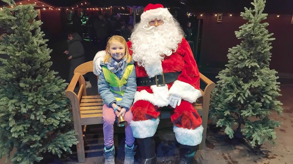 Emma (7) aus Rhauderfehn ließ sich mit dem Weihnachtsmann auf dem Adventsmarkt fotografieren. Foto: Clarissa Scherzer