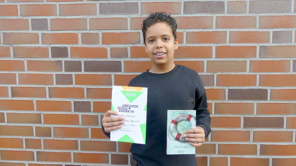 Julian Bruns aus der Klasse 6.3 freut sich über seinen Sieg beim Vorlesewettbewerb und den Buchgutschein des Fördervereins. Foto: Ulrike Janssen