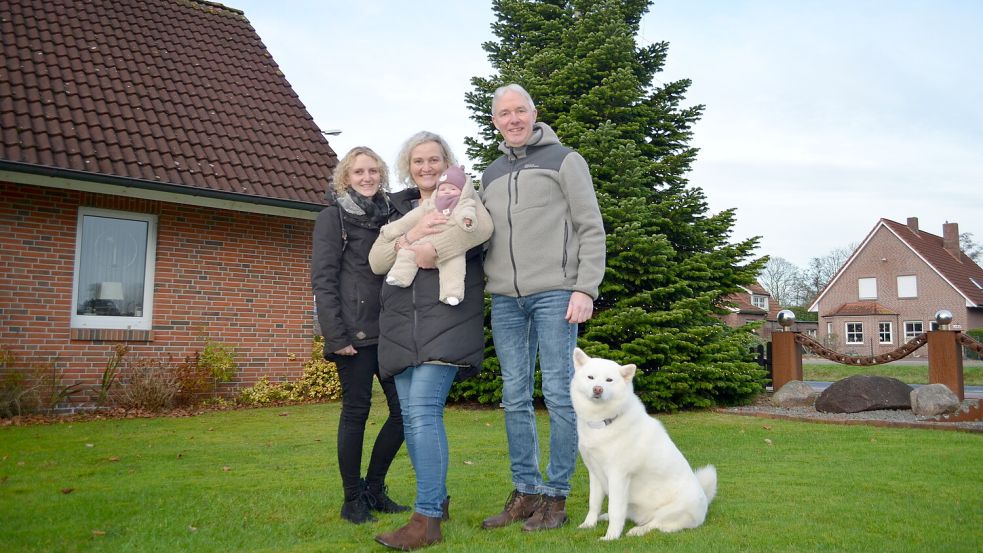 Vor der Weihnachtstanne im Vorgarten stehen hier Svenja Rotman, geb. Goldsweer, und deren Eltern Heike und Karl-Dieter Goldsweer. Sohn Kai Goldsweer fehlte berufsbedingt. Heike Goldsweer hat die zehn Wochen alte Hilke auf dem Arm, das erste Enkelkind der Familie. Hündin Alaska gehört natürlich auch dazu. Foto: Astrid Fertig