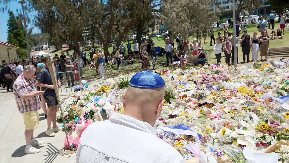 Menschen legen bei einer Gedenkfeier für die Opfer eines Terrorangriffs am Bondi Beach in Sydney Blumen nieder. (Foto aktuell) Foto: Flavio Brancaleone