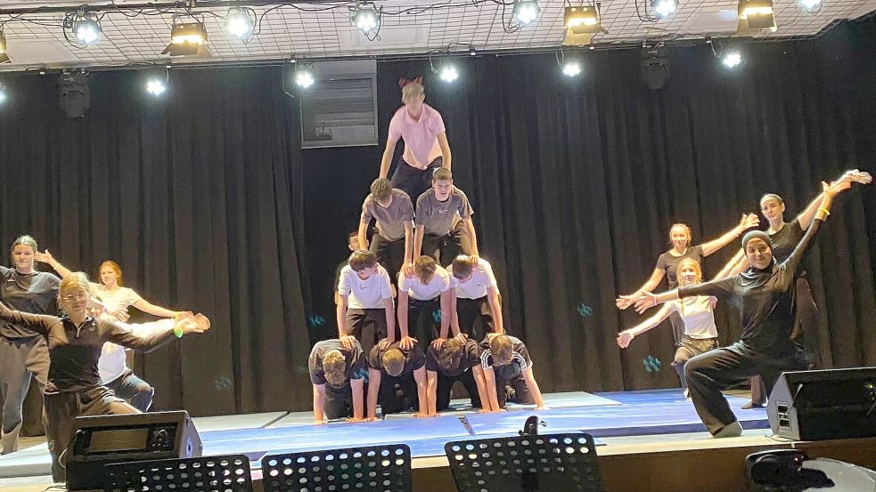 Schülerinnen und Schüler zeigen beeindruckende Akrobatik auf der Bühne der Aula. Foto: HRS/Miriam Kösters