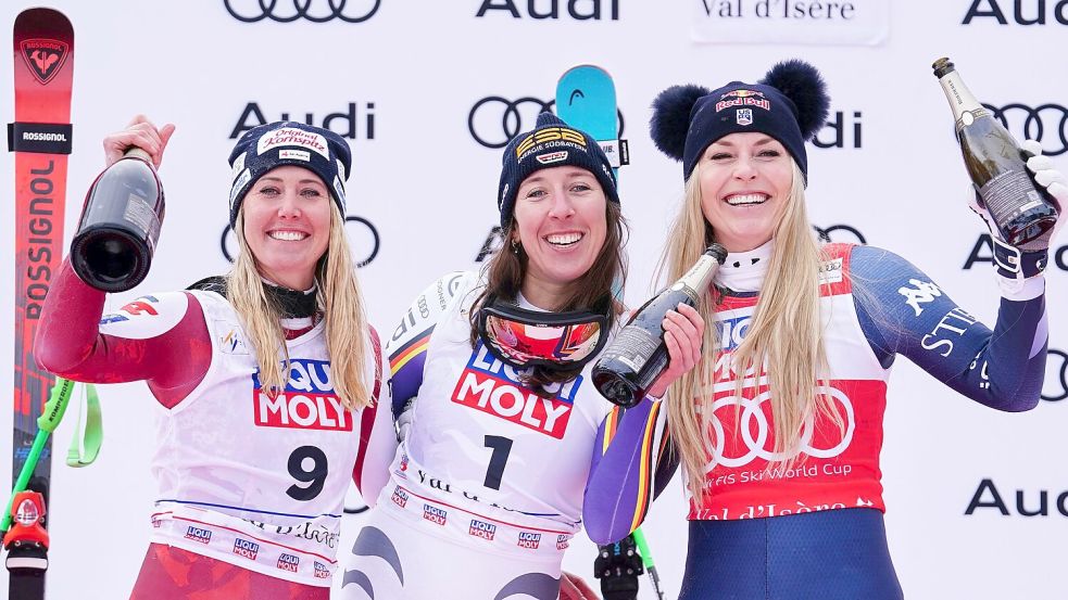 Neben Siegerin Hütter (links) und der drittplatzierten Vonn (rechts) lässt es sich gut feiern. Foto: Pier Marco Tacca/AP/dpa
