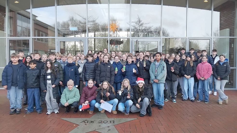 Die Schülerinnen und Schüler des Albrecht-Weinberg-Gymnasiums versammeln sich vor der Schule für ein Gruppenfoto, bevor sie zum Seniorenzentrum Rhaudermoor aufbrechen. Foto: Clarissa Scherzer