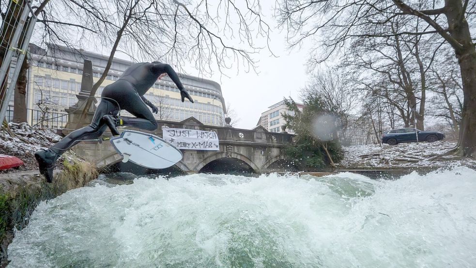 Ein Weihnachtswunder? Auf dem Eisbach wird wieder gesurft. Foto: Peter Kneffel/dpa