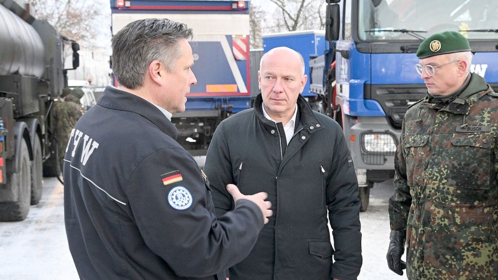 Oliver Schultz (l-r) vom Technischen Hilfswerk, Kai Wegner (CDU), Regierender Bürgermeister, und Brigadegeneral Horst Busch, unterhalten sich. Foto: Jens Kalaene