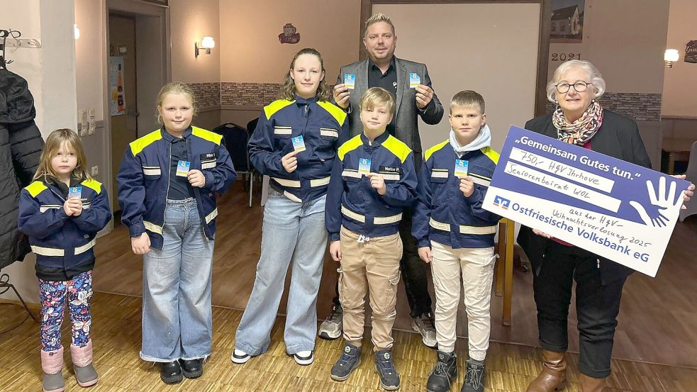 Nele Bakker (von links), Mira Visser, Merle Visser, Mattes Polzin und Hilko Schütte von der Kinderfeuerwehr Ihrhove haben die Gewinnnummern der Weihnachtsverlosung des Handels- und Gewerbevereins (HGV) Ihrhove gezogen. HGV-Vorsitzender Holger Schütte (hinten) konnte anlässlich der Ziehung einen symbolischen Scheck über 750 Euro an Ulla Korte vom Seniorenbeirat der Gemeinde Westoverledingen überreichen. Foto: HGV Ihrhove