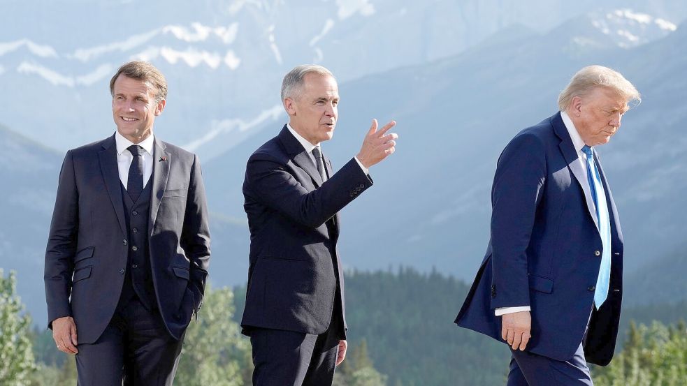 2025 war Kanadas Premierminister Mark Carney (Mitte) Gastgeber des G7-Gipfels, in diesem Jahr wird Frankreichs Präsident Emmanuel Macron (l) US-Präsident Donald Trump (r) und die anderen G7-Chefs empfangen. (Archivbild) Foto: Darryl Dyck/The Canadian Press/A