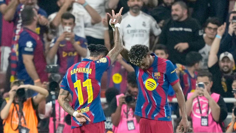 Barcelonas Raphinha (l) feiert mit Teamkollege Lamine Yamal den Führungstreffer. Foto: Altaf Qadri/AP/dpa