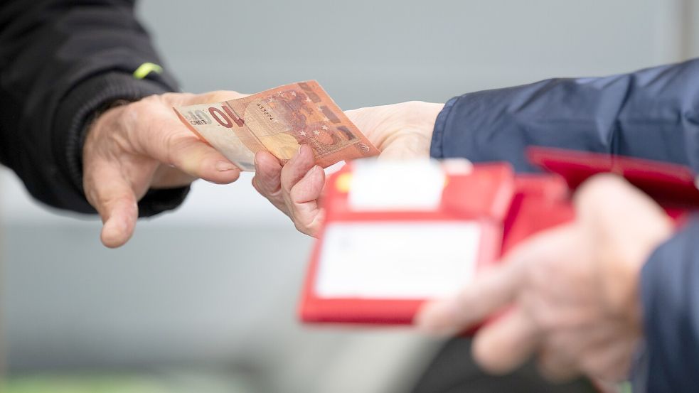 Ein Mann bezahlt mit Bargeld. Symbolfoto: Sebastian Kahnert/dpa