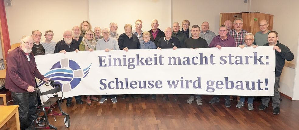 Bei der Auflösung hielten die Mitglieder des Vereins „Bürgerinitiative Rettet den Elisabethfehnkanal“ noch einmal das damalige Erfolgsplakat hoch. Foto: Hans Passmann
