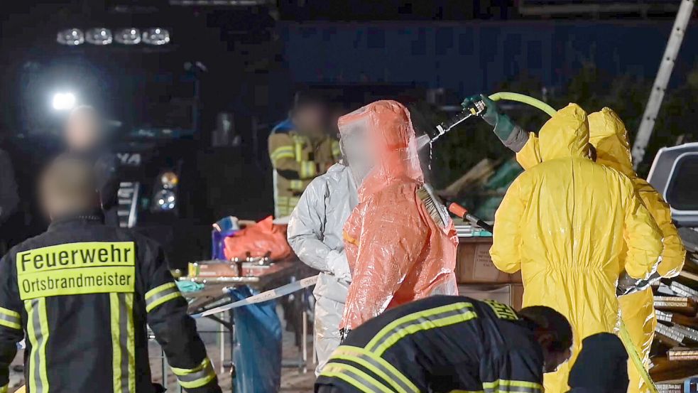 Einsatzkräfte der Feuerwehr dekontaminieren am 16. Januar in Papenburg einen Polizeibeamten in einem Gefahrenstoffanzug. In einem Schlag gegen die Organisierte Kriminalität haben Einsatzkräfte im größten europäischen Ermittlungskomplex zu synthetischen Drogen in mehreren europäischen Ländern Labore zerschlagen und tonnenweise Chemikalien und Drogen sichergestellt. Foto: Lars Penning/dpa
