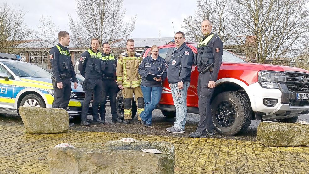 Noch stehen Betonpoller auf dem Festplatz – bald beginnt der Aufbau von zwei Festzelten. Einsatzleiter Henning Kröger (links) traf sich dort mit Christian Erdmann, Raphael Olling, Ortsbrandmeister Matthias Schulte, Vera Deutzmann, Matthias Krause (DRK) und Uwe Tiedeken zu letzten Absprachen. Foto: Horst Wilken