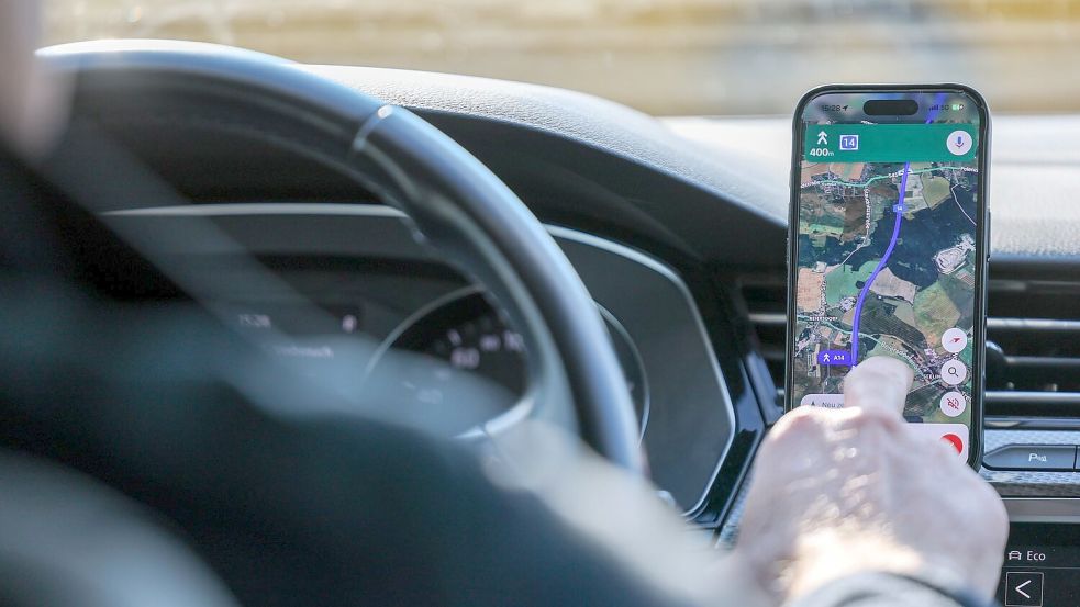 So ist es derzeit erlaubt: Das Handy steckt in der Halterung und wird nur kurz vom Fahrer beachtet. (Symbolbild) Foto: Jan Woitas