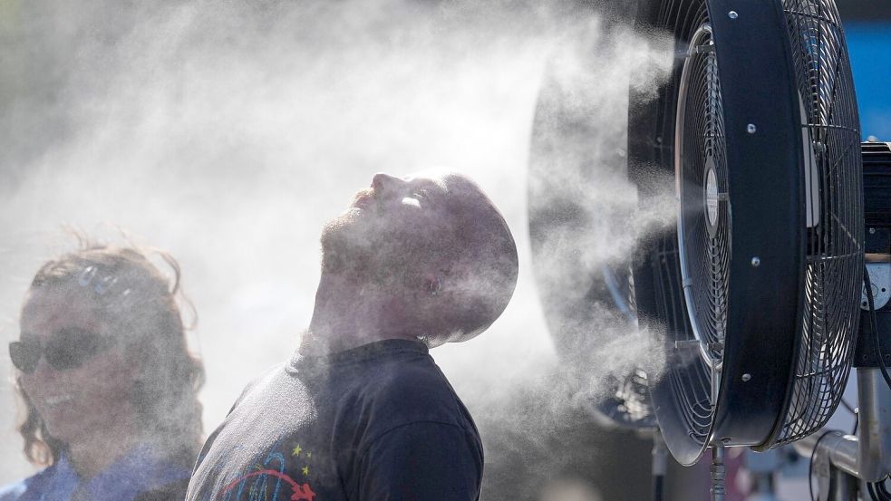 Die Behörden forderten die Menschen auf, sich immer wieder abzukühlen. Foto: Dita Alangkara/AP/dpa