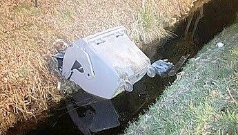 Die Unbekannten haben einen großen Abfallcontainer in den Graben geworfen, der sich direkt neben der Grundschule befindet. Fotos: Gemeinde Ostrhauderfehn