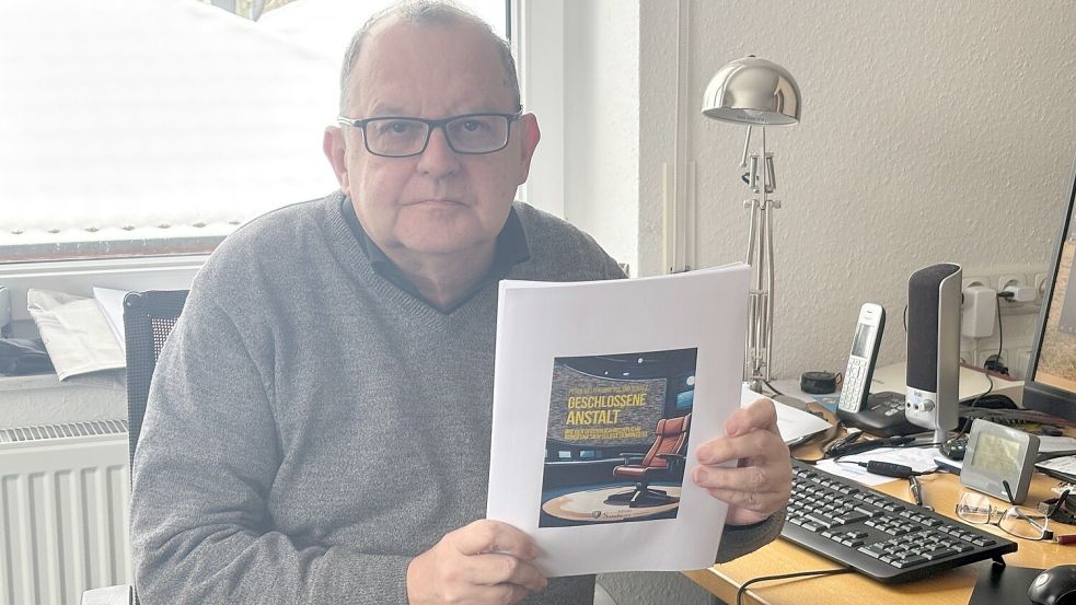 Peter Welchering sitzt in seinem Büro in Ostrhauderfehn und hält eine Kopie des Covers des Buches in den Händen. Zum Zeitpunkt des Gesprächs war das Buch noch nicht gedruckt. Foto: Horst Kruse