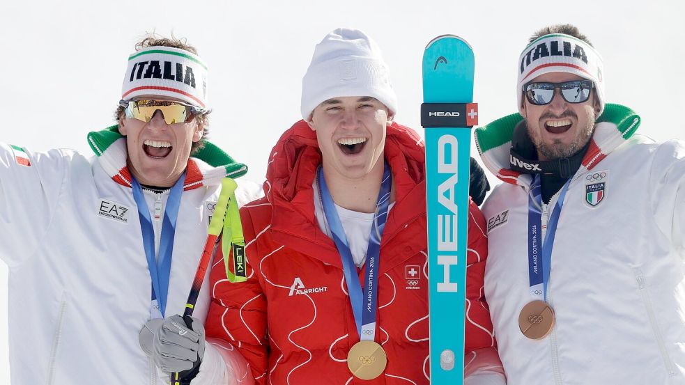 Olympiasieger Franjo von Allmen wird flankiert von Silber-Gewinner Giovanni Franzoni (links) und dem Drittplatzierten Dominik Paris. Foto: Oliver Weiken
