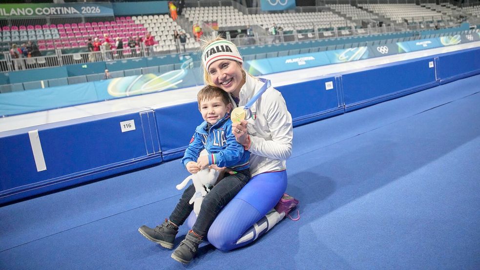 Francesca Lollobrigida feiert mit ihrem kleinen Sohn Tommaso den Olympiasieg. Foto: Christophe Ena/AP/dpa