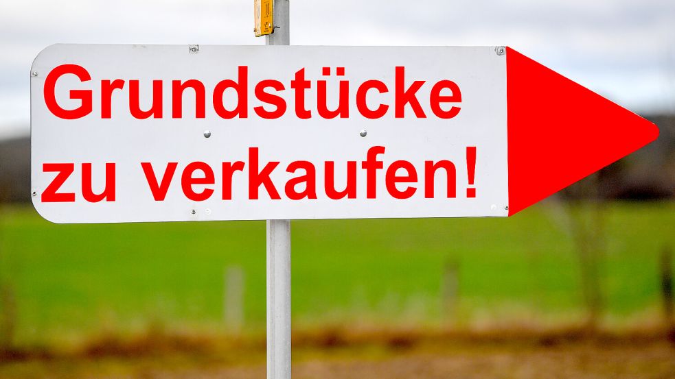 Ein Schild mit der Aufschrift „Grundstücke zu verkaufen!“ steht an einer Straße. 2025 wurden in Ostfriesland 15 Prozent mehr Baugrundstücke verkauft als im Jahr zuvor. Foto: Patrick Pleul/dp