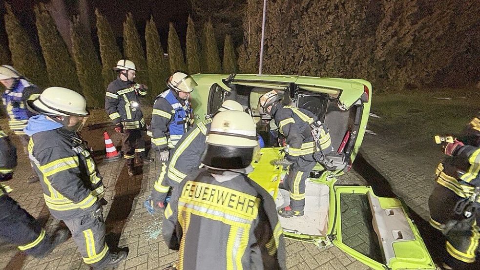Einsatzkräfte der Feuerwehr Westrhauderfehn proben die Rettung aus einem auf der Seite liegenden Auto. Foto: Dirk Hellmers