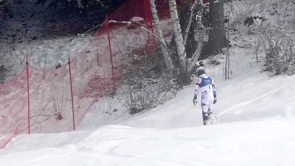 Ein Bild dieser Winterspiele: Atle Lie McGrath stapfte nach seinem Aus im Slalom einsam durch den Schnee in Richtung eines Waldstück. Foto: John Locher/AP/dpa