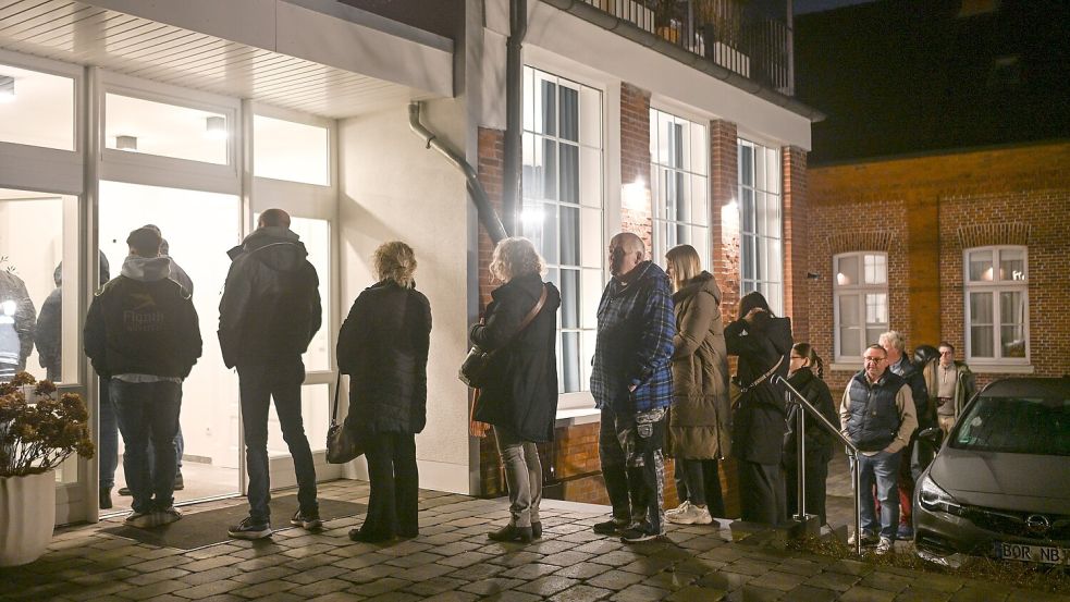 Zahlreiche Patienten stehen in den frühen Morgenstunden vor der Arztpraxis in Weener, die eine offene Sprechstunde anbietet.  Foto: Lars Penning/dpa