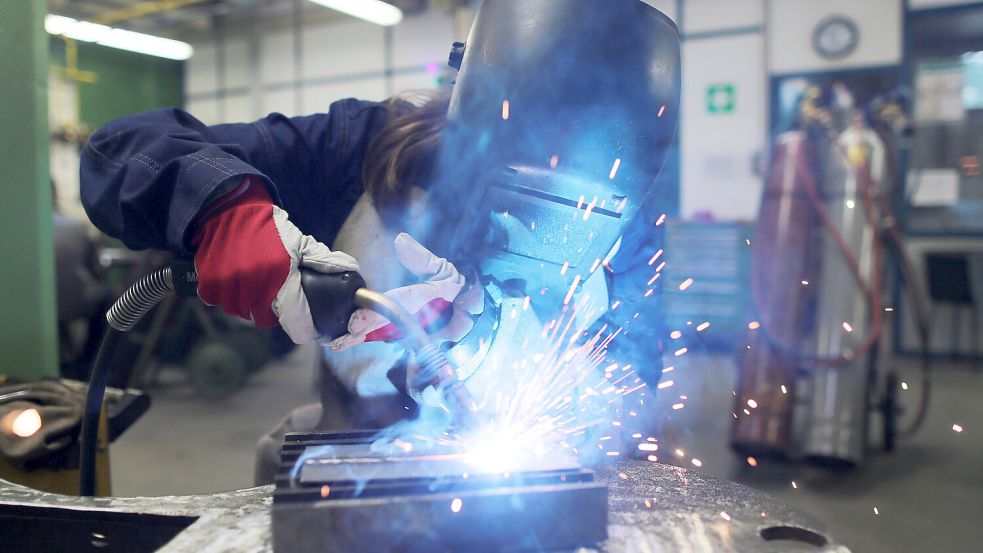 Eine Auszubildende zur Schweißerin arbeitet an einem Stück Metall: Die gewerblich-technischen Berufe erleben in Ostfriesland einen regen Zulauf. Foto: Oliver Berg/dpa/Archiv