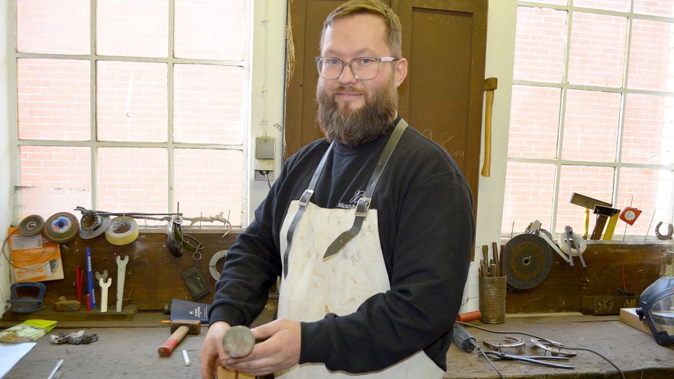 Michael Kröger mit einem der Friedensnägel, die er schmiedet. Auf den Nagelkopf ist eine Friedenstaube geprägt. Die Nägel werden mit einem Zertifikat versehen und für 100 Euro verkauft. Der Erlös kommt vollständig caritativen Zwecken zugute. Foto: Astrid Fertig