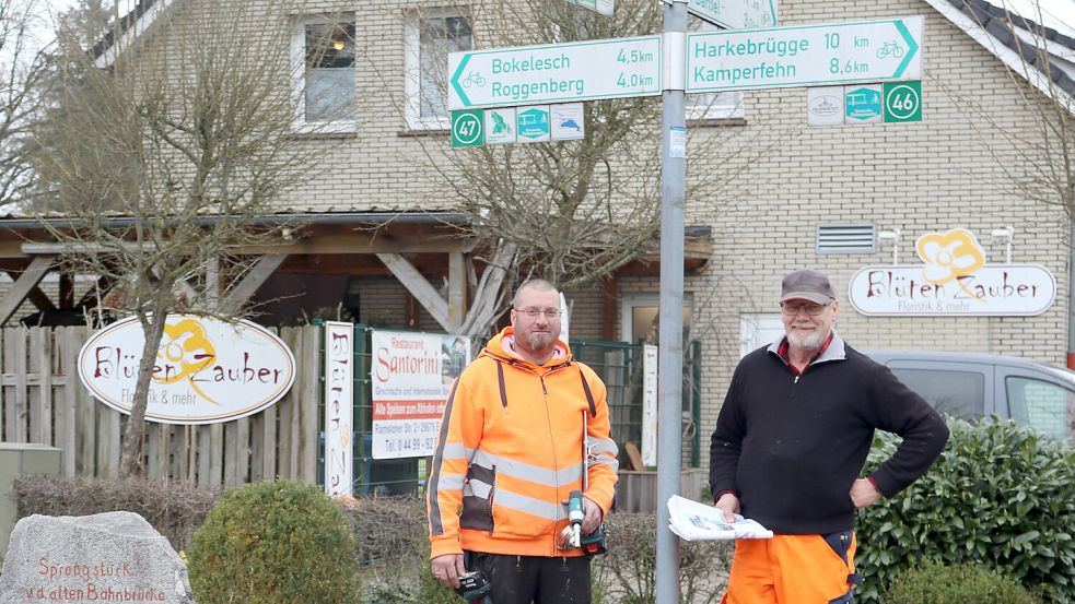 Auf dem Bild haben (von links) die Mitarbeiter des Bauhofs Thomas Kreke und Josef Schmidt das Schild für den Knotenpunkt 48 an der Ecke Mühlenstraße/Hauptstraße in Dreibrücken angebracht. Foto: Gemeinde Barßel