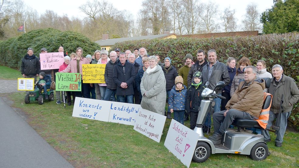 Sie zeigen Gesicht, um kundzutun, dass sie nicht einverstanden sind damit, was Florian Bock im Jugendheim am Alten Scharreler Damm 12 für Aktivitäten plant: Anwohnerinnen und Anwohner stellten sich am Donnerstag mit Plakaten vor dem Gebäude auf. Sie befürchten durch die Nutzung des Hauses als Seker Huus vom Verein Punk4Punx Lärm, Ärger und Park-Chaos in ihrer ruhigen, ländlichen Nachbarschaft. Foto: Astrid Fertig