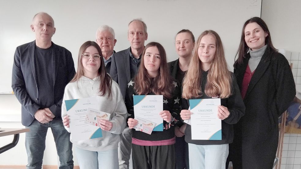 Sidney Zahn (vorne, von links), Alea Zibell und Kim Lea Tautermann aus der R9a sammelten als stärkstes Team 500 Euro für die Kriegsgräberpflege und erhielten für die herausragende Leistung Kinogutscheine; (hinten, von links) Schulleiter Ludger Mählmann, Folkert Laupichler (Volksbund), Teo Bildhauer (Lehrkraft Geschichte), Kristine Seibel (Bildungsreferentin Oldenburg) und Saskia Glogowski (Bezirksgeschäftsführerin Bezirk Weser-Ems). Foto: Clarissa Scherzer
