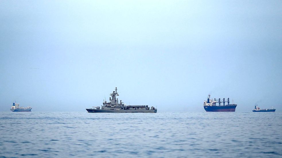 Als Folge des Iran-Krieges ist die für Öllieferungen wichtige Straße von Hormus nahezu blockiert. Hier patrouilliert ein Marine-Schiff der Vereinigten Arabischen Emirate neben Frachtschiffen und Öltankern dort. Foto: Altaf Qadri/AP/dpa