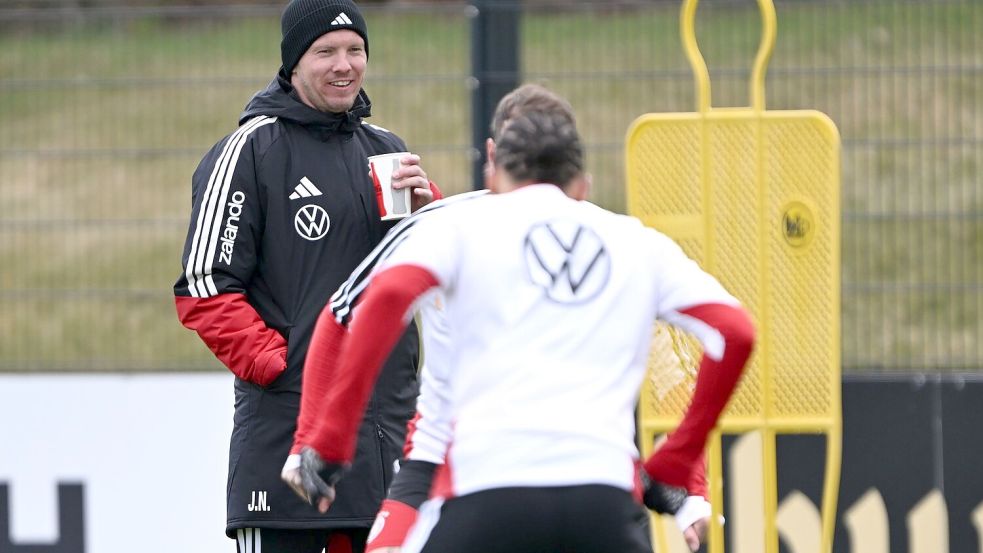 Warm eingepackt verfolgt Bundestrainer Julian Nagelsmann das Geschehen auf dem Trainingsplatz. Foto: Federico Gambarini/dpa