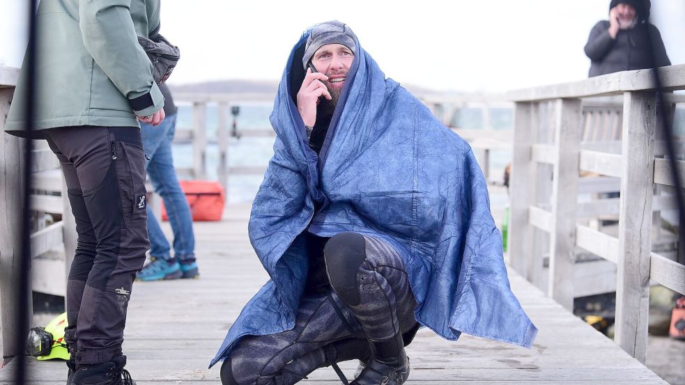 Robert Marc Lehmann geht auf Tuchfühlung mit einem gestrandeten Wal in der Ostsee. Foto: Daniel Bockwoldt