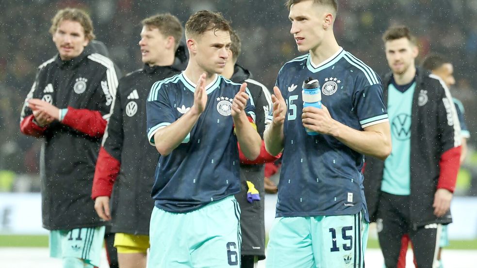 Nico Schlotterbeck (r.) spricht auf dem Platz mit DFB-Kapitän Joshua Kimmich. Foto: Christian Charisius/dpa