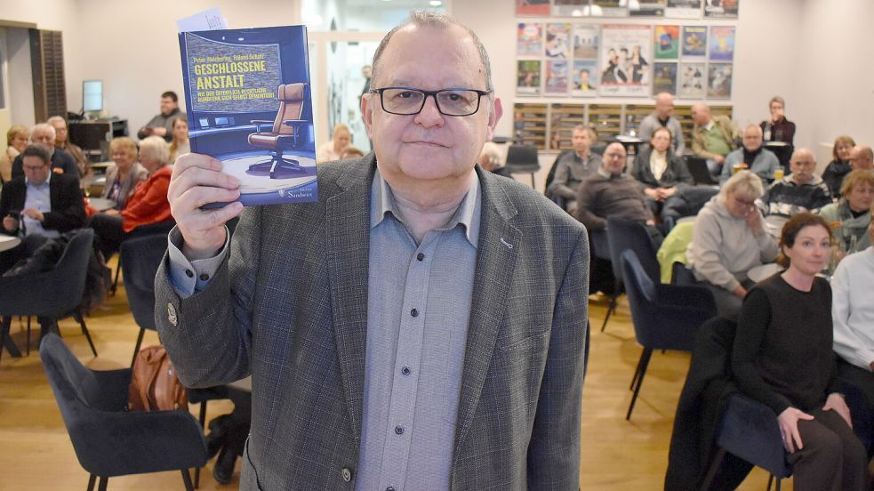 Peter Welchering präsentiert sein Buch „Geschlossene Anstalt“ – im Hintergrund das vollbesetzte Fehntjer Forum in Westrhauderfehn. Foto: Henrik Zein