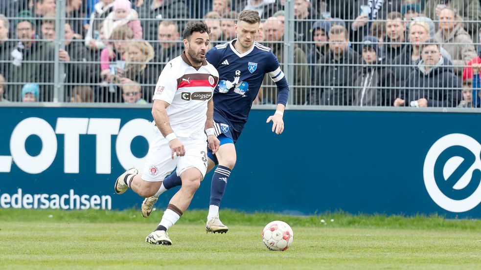 Kickers-Kapitän Dennis Engel (blaues Trikot) im Zweikampf mit dem Ex-Emder Nikky Goguadze. Foto: Jens Doden/Emden