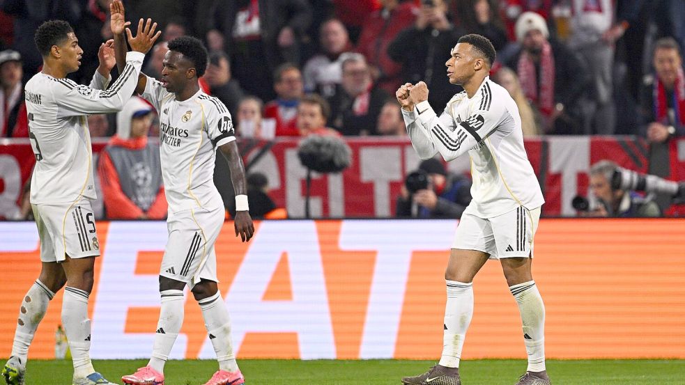 Reals Stürmerstar Kylian Mbappé jubelt mit Vinícius Júnior und Jude Bellingham (vr) nach seinem Tor zum 3:2.   Foto: Tom Weller