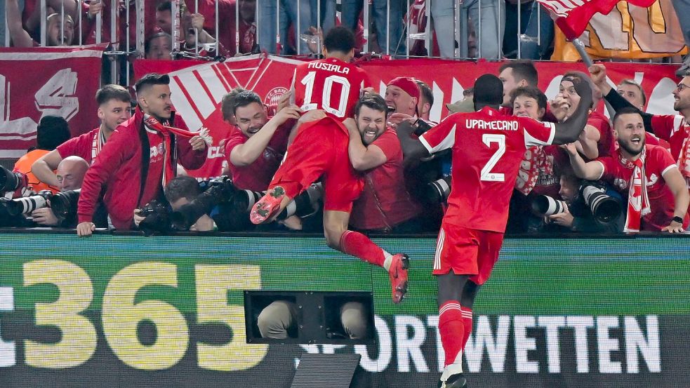 Nach dem letzten Bayern-Tor gegen Real springen einige Münchner Fans und Bayern-Profi Jamal Musiala im Jubel den anwesenden Fotografen in den Rücken. Foto: Sven Hoppe