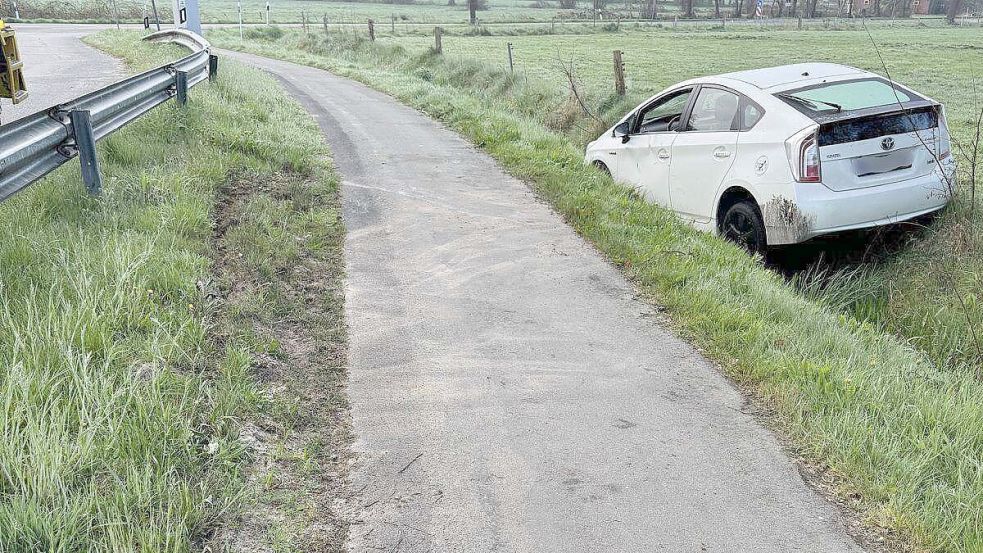 Ein weißer Toyota Prius liegt nach dem Unfall im Straßengraben an der Großwolder Straße in Westoverledingen. Foto: Daniel Grüneke