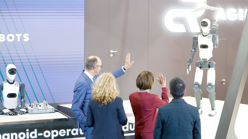 Bundeskanzler Friedrich Merz winkt einem Roboter zu – die Zukunft winkt zurück. Foto: Michael Matthey