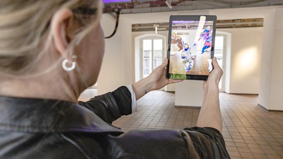 Realer Raum mit künstlicher Erweiterung: Inga Seidler, Kuratorin der EMAF-Ausstellung führt im Foyer der Kunsthalle Osnabrück die „Arbeit Alternatives Denkmal für Deutschland (ADfD)“ vor. Foto: Sebastian Dannenberg