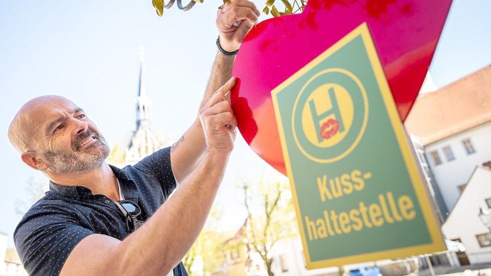 Café-Betreiber Jost Samorski will mit seiner „Kusshaltestelle“ in Eisenberg Passanten zum Küssen animieren. Foto: Jacob Schröter/dpa