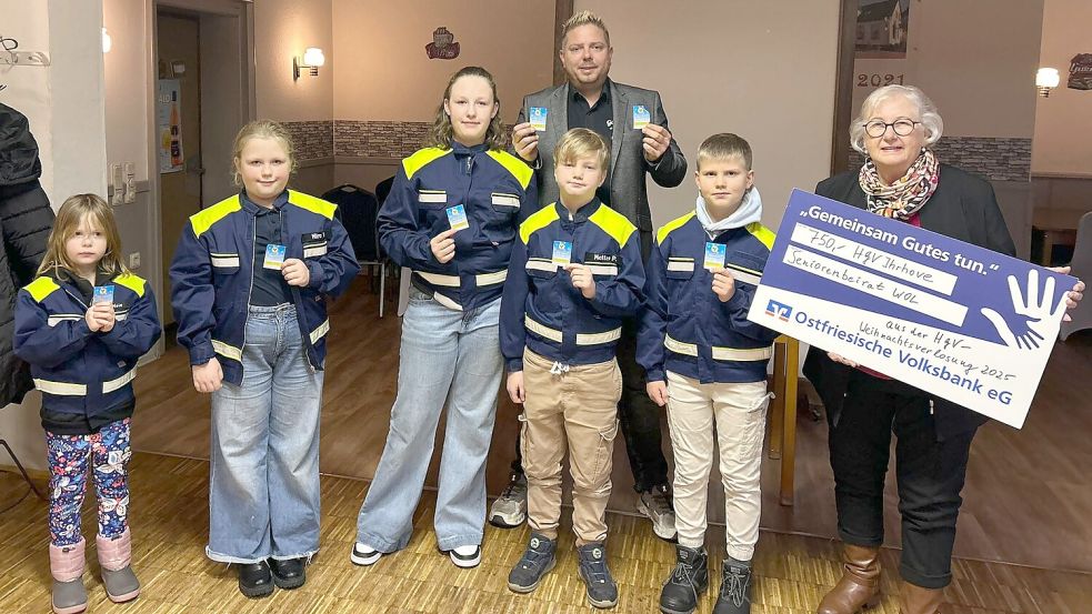 Im Januar 2026 hatten Nele Bakker (von links), Mira Visser, Merle Visser, Mattes Polzin und Hilko Schütte von der Kinderfeuerwehr Ihrhove die Gewinnnummern der Weihnachtsverlosung gezogen. HGV-Vorsitzender Holger Schütte (hinten) konnte anlässlich der Ziehung einen symbolischen Scheck über 750 Euro an Ulla Korte vom Seniorenbeirat der Gemeinde Westoverledingen überreichen. Foto: HGV Ihrhove